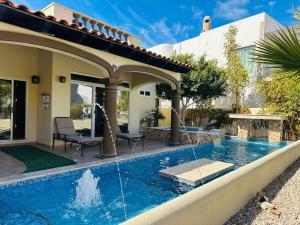 a house with a swimming pool with a fountain at Casa Playas in Puerto Peñasco