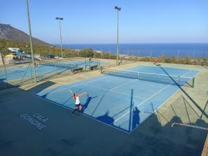 una mujer está jugando al tenis en una pista de tenis en Casa al mare Orchidea - Motoparking - Wifi Free - AC, en Cala Gonone