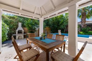 a wooden table and chairs on a patio with a fireplace at Wunderschöne Villa Gardenia In Istrien in Premantura +32 photos