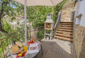 a balcony with a table with food and an umbrella at Casa Picachico in Laroya