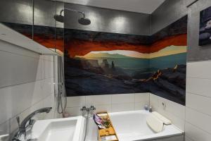 ein Badezimmer mit Badewanne und einem Gemälde an der Wand in der Unterkunft 5 Sterne Ferienwohnung Zirbe mit eigener Infrarotsauna und Whirlpoolbadewanne in Arnbruck + 27 Fotos