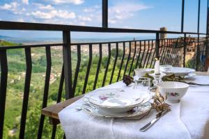 a table with plates and cups on top of a balcony at Wohnung La Volata In Massa E Cozzile in Massa e Cozzile