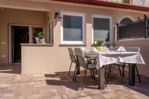 a table and chairs sitting on a patio at Ferienhaus Mit Whirlpool Und Sauna, In Kastelir in Kaštelir