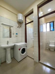 a bathroom with a washing machine and a sink at CITY Que2ens in Arusha +59 photos