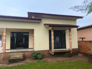 a house with two large windows in a yard at Paraíso chama in Jaguaruna