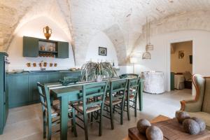 a kitchen and dining room with a green table and chairs at CRIO - Experiences at home in Cisternino