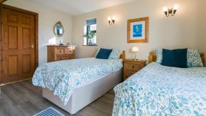 a bedroom with two beds and a mirror at Moranedd in Llanfaethlu