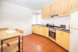 RazoにあるAG Casa Arroaces Razo, a 200m de la playaの木製のキャビネットとコンロ付きオーブンを備えたキッチン