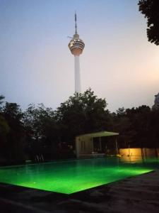 einen beleuchteten Pool mit einem Turm im Hintergrund in der Unterkunft Suasana Bukit Ceylon KLCC by SwiftTravels in Kuala Lumpur