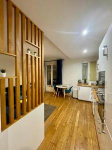 a kitchen and living room with a wooden floor at Appartement Porte de Versailles Olivier de Serre in Paris +15 photos