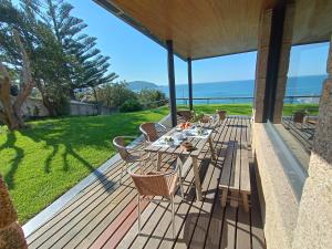 a wooden deck with a table and chairs on it at MARdeCIES Chalet de vacaciones in Vigo