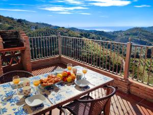 ein Tisch mit einem Teller Essen auf einem Balkon in der Unterkunft Holiday Home Tres Palmeras by Interhome in Frigiliana