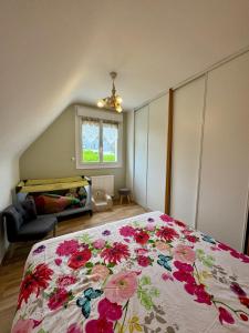 ein Schlafzimmer mit einem Bett mit geblümter Tagesdecke in der Unterkunft Maison familiale - Côte de Granit Rose in Saint-Quay-Perros + 31 Fotos