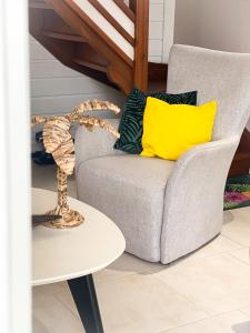 a living room with a chair and a table at Ka Villa Location in Pointe-Noire +9 photos