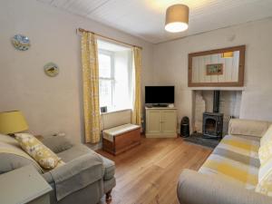 a living room with a couch and a fireplace at Woodland Cottage in Arisaig
