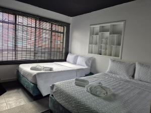 a bedroom with two beds and a window at Hotel Capital HEU in Bogotá