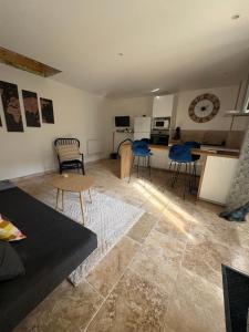 a living room with a table and chairs and a kitchen at Domus de la Pierre in Autun