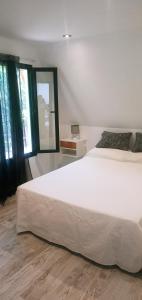 a bedroom with a large white bed and windows at Lapachos blco cabañas in Federación