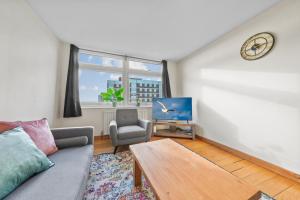 a living room with a couch and a table at Premier Suites Shepherds Bush Westfields Penthouse Apartment in London