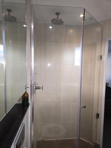 een douche met een glazen deur in een badkamer bij Lovely one private bedroom in shared 2 bedroom apartment in Manchester