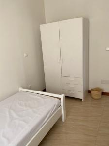 a bedroom with a bed and a white cabinet at Casa Carveiros Panoramic 360 in Tarrafal +22 photos