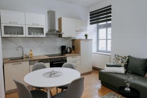 a kitchen and living room with a table and a couch at Apartmani Mesko in Gospić