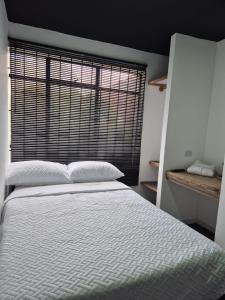 a bedroom with a white bed and a window at Hotel Capital HEU in Bogotá +12 photos