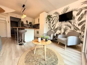 a living room with a table and a kitchen at Maison du Cap Jacuzzi Wifi Clim Parking Court de tennis à 100m in Cap d'Agde