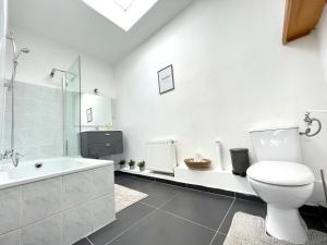 een witte badkamer met toilet en ligbad bij Beautiful & Charming studio EU DISTRICT in Brussel