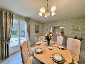 ein Esszimmer mit einem Holztisch und Stühlen in der Unterkunft Maison Angelo - Piscine - Jardin - 6p in Sillé-le-Philippe