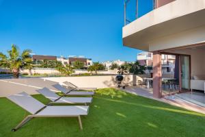 a group of lounge chairs on the lawn of a building at Michael in Torre de la Horadada