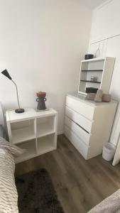 a white bedroom with a bed and a desk at Convenient Home-stay in London