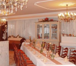 a dining room with a long table and chairs at Hotel Igel in Püchersreuth