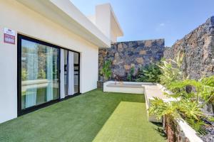 an outdoor patio with a bench and grass at ISLAND WEEK Fuerteventura in La Oliva