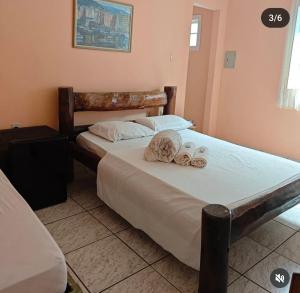 a bedroom with two beds with shoes on them at Pousada do Deck in Alcobaça