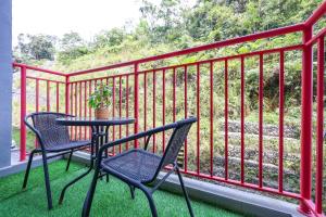 a patio with two chairs and a table on a balcony at Family Retreat Cozy Stay in Cameron- Clover Home M-08 in Brinchang
