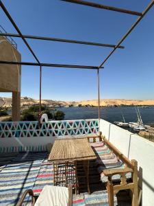 a patio with a table and benches on a roof at Nubian King in Aswan +48 photos