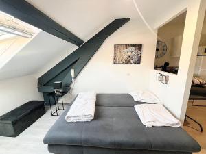 a black bed in a room with a staircase at Appartement moderne et central in Belfort