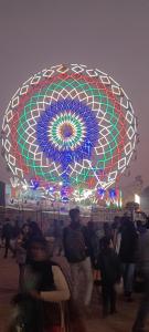a crowd of people standing in front of a ferris wheel at Shashi Bhawan in Prayagraj