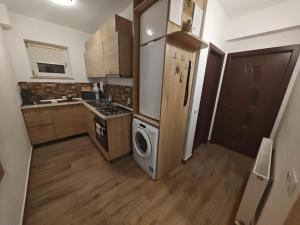 a small kitchen with a stove and a washer and dryer at Apartament Luca in Călimăneşti +46 photos