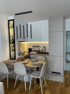 a kitchen with a wooden table and chairs in a room at Zlatkovic Family in Pirot +13 photos