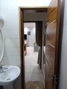 ein Bad mit einem Waschbecken, einem WC und einer Tür in der Unterkunft Résidence Angéline 4 studios in Yassa + 57 Fotos