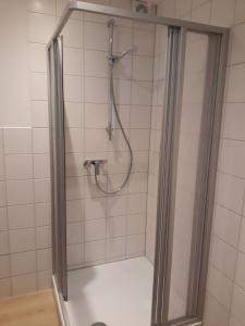 une douche avec une porte vitrée dans une salle de bain dans l'établissement Ferienhaus Würzgarte, à Ürzig