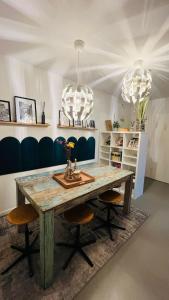 a dining room with a wooden table and two chandeliers at Daheim in Essen in Essen