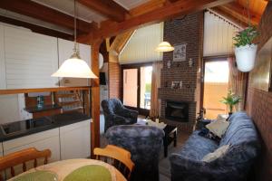 a living room with a couch and a fireplace at Ferienhaus Sandfoort In Friedrichskoog Spitze in Friedrichskoog