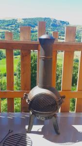 a stove sitting on a table in front of a fence at Cabanes Milvus du Puy Mary in Cheylade