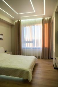 een slaapkamer met een bed en een groot raam bij Avenue Boutique Luxury N3 in Chişinău