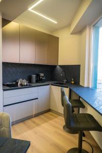een keuken met witte kasten en een tafel en stoelen bij Avenue Boutique Luxury N3 in Chişinău