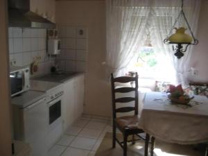a small kitchen with a table and a window at Große Ferienwohnung Mit Balkon Und Garten in Steinen