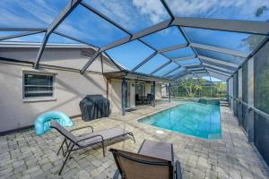 un patio con piscina con techo de cristal en 3 Mi to Naples Botanical Garden Home with Hot Tub!, en Naples